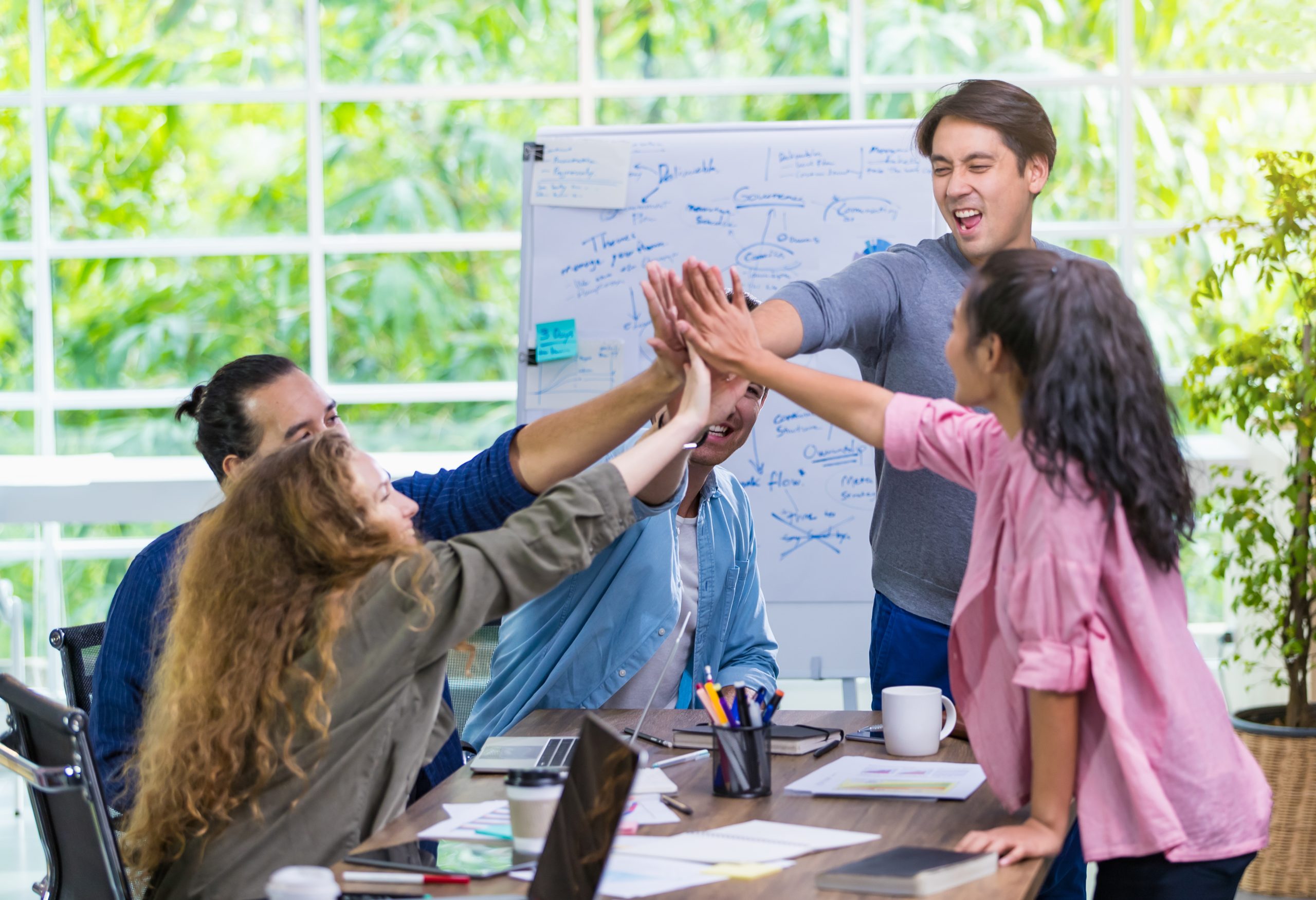 Multiethnic casual businesspeople putting their hands together t